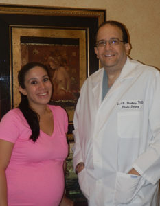 Dr. Glasberg posing with a pregnant staff member
