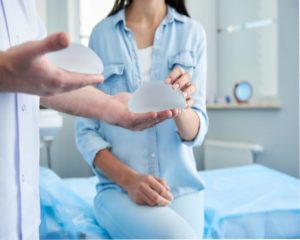 medical professional showing female patient breast implants
