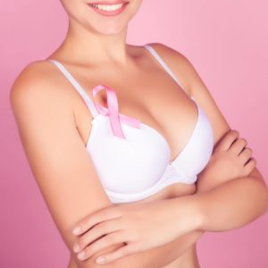 woman wearing white bra with breast cancer pin
